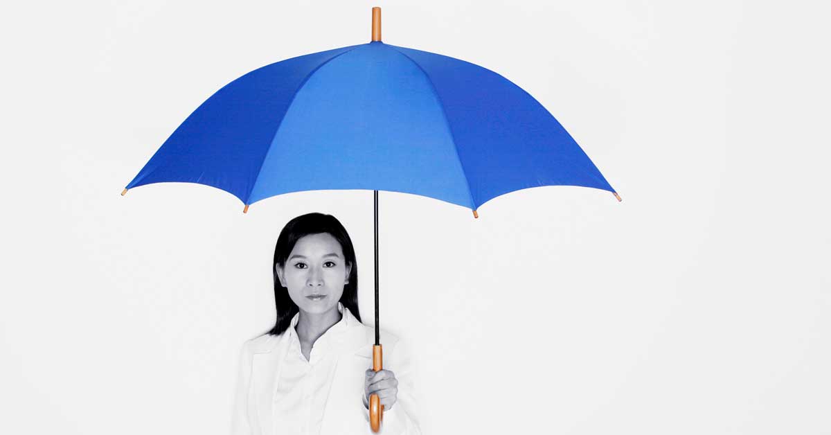 Asian woman holding a blue umbrella over her head