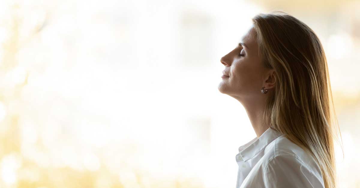 Woman with long blonde hair with eyes closed as if she is meditating